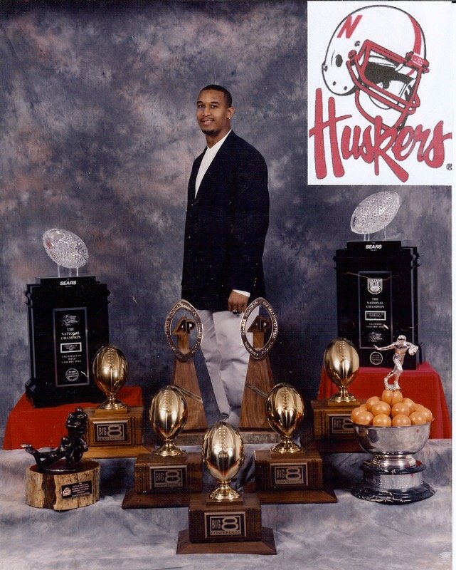 Larry Arnold photographed with Nebraska championship trophies